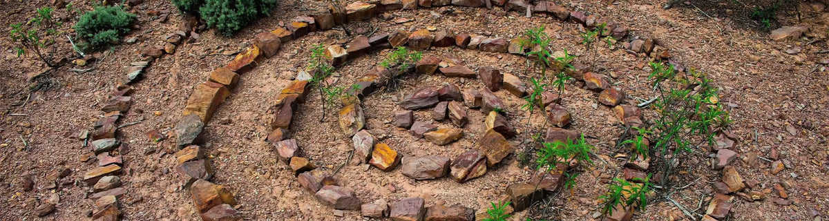 Earth element banner: stones neatly placed in a spiral - intention made visible